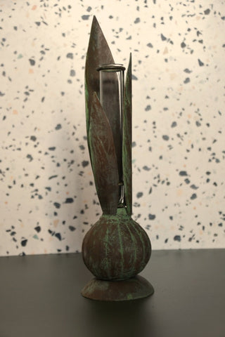 Bronze sculpture with a textured surface on a speckled background