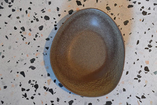 Brown ceramic plate on a speckled surface