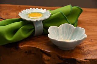 Decorative ceramic items on a wooden surface with green fabric