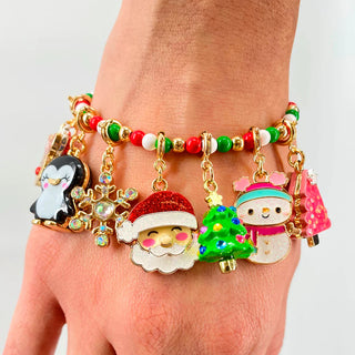 Bracelet with Christmas-themed charms on a wrist against a white background