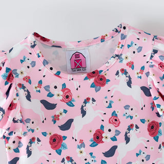 Pink children's outfit with unicorn and floral pattern on a white background
