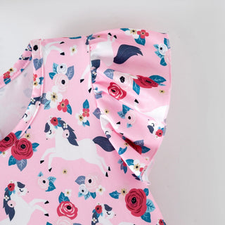 Pink children's outfit with floral and unicorn pattern on a light gray background