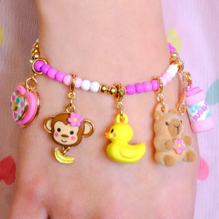 Colorful bracelet with animal charms on a wrist against a pink background