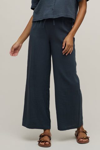 Person wearing navy wide-leg pants on a plain background