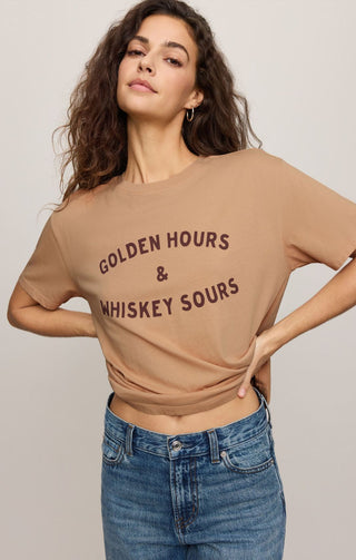 Woman wearing a beige t-shirt with text, standing against a plain background