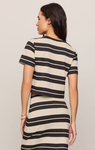 Woman wearing a black and beige striped dress against a plain background