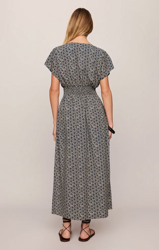 Woman wearing a patterned dress against a plain background
