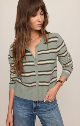 Woman wearing a striped sweater and jeans against a plain background
