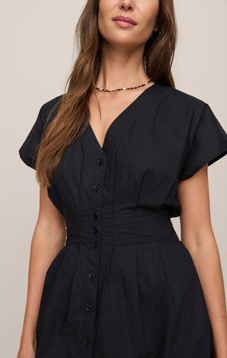 Woman wearing a black dress with a plain background