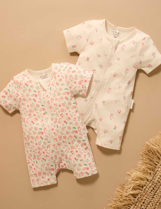 Two floral-patterned baby rompers on a beige background