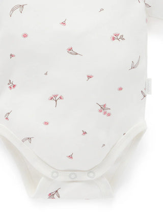 White baby onesie with pink floral pattern on a white background