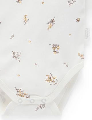 White baby onesie with floral embroidery on a white background