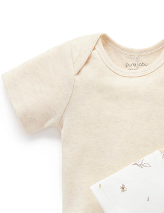 Beige baby onesie with 'pure labu' branding on a white background