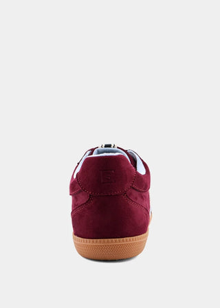 A single low-top sneaker shown from the back, featuring burgundy suede uppers, a light blue lining, and a brown gum sole, set against a plain light gray background.