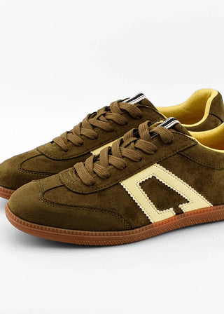 A pair of low-top suede sneakers in olive brown, featuring a large cream-colored geometric side stripe, matching brown laces, and a gum brown sole.