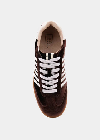 A single dark brown suede sneaker shown from a top-down view, featuring white laces and three white stripes on the side, set against a light gray background.