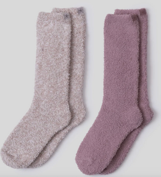 Two pairs of fuzzy socks, one gray and one purple, on a light gray background.