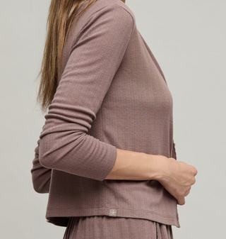 Person wearing a brown long-sleeve top and pants on a plain background