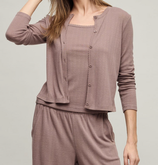 Person wearing a mauve pajama set on a plain background