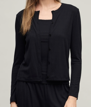 Black cardigan over a black top on a plain background