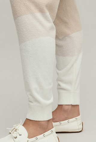 Close-up of white pants and white shoes on a plain background