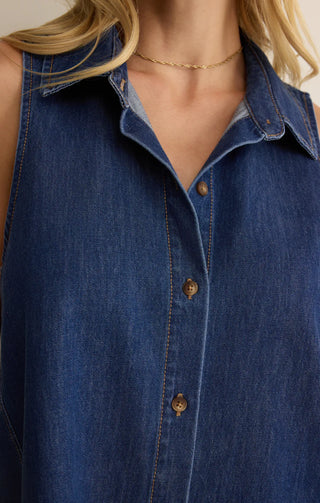Close-up of a person wearing a blue denim shirt with a blurred background