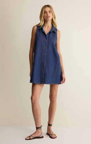 Woman wearing a denim dress on a beige background
