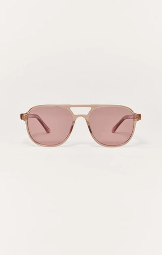 Sunglasses with pink lenses and gold frame on a white background