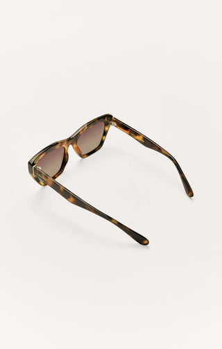 Sunglasses with tortoiseshell frame and brown lenses on a white background