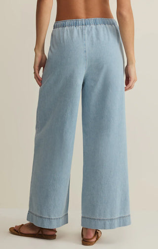 Light blue wide-leg pants worn by a person on a beige background