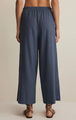 Blue pants worn by a person on a beige background