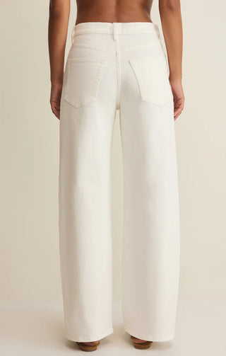 White wide-leg pants worn by a person on a beige background