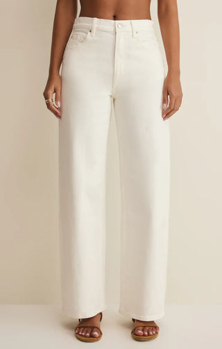 Person wearing white wide-leg jeans on a plain background