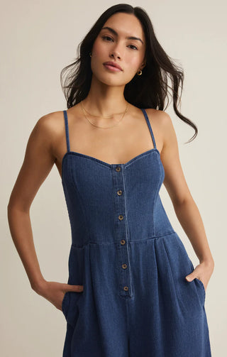 Woman wearing a blue denim dress against a neutral background