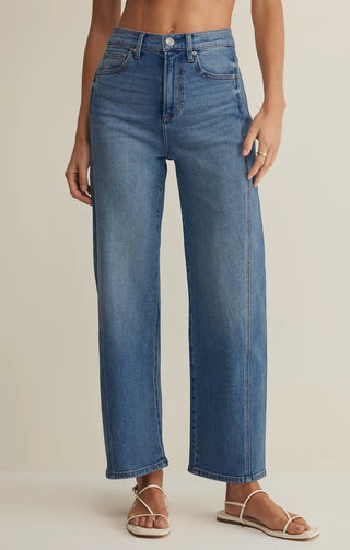 Blue jeans worn by a person on a beige background