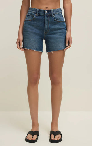 Person wearing blue denim shorts on a plain background