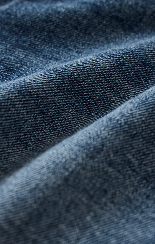 Close-up of blue denim fabric with a subtle pattern