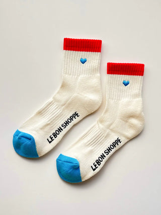 White socks with red tops and blue toes and heels, featuring hearts and 'LEBON SHOPPE' branding on a light gray background.