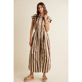 Woman wearing a brown and beige striped dress on a beige background