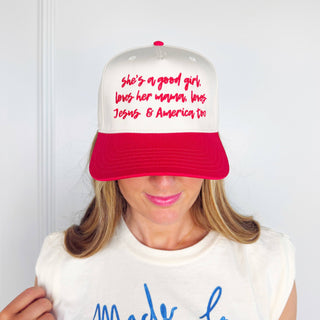 Person wearing a white and red cap with text, against a plain background