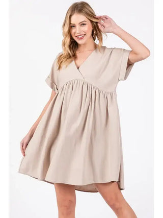 Woman wearing a beige dress on a white background