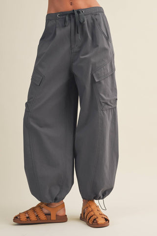 Gray cargo pants worn by a person on a beige background