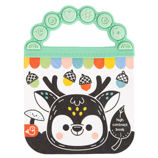 A children's high-contrast baby book with a mint green handle and a playful forest illustration featuring a black deer face, colorful acorns, and a mushroom on a white background.