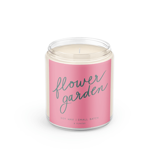 Candle in a jar with a pink label reading 'flower garden' on a white background