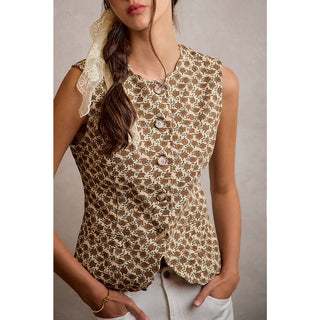 Woman wearing a sleeveless floral top with a neutral background