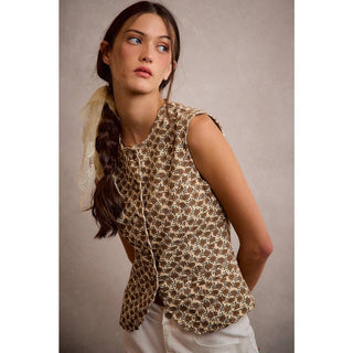 Woman wearing a patterned sleeveless top against a neutral background