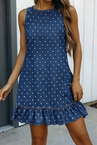 Woman wearing a blue polka dot dress with a ruffled hem.