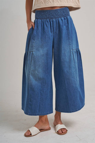 Blue denim wide-leg pants worn by a person on a plain background