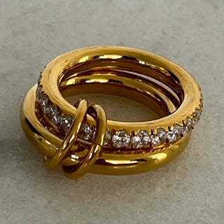 Gold ring with diamond accents on a light gray background