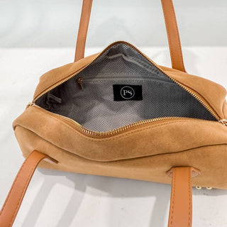 Brown leather bag with visible brand logo on a white background